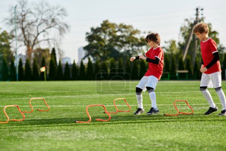 Photo for Two young boys wearing soccer jerseys are energetically playing soccer on a grass field. They are passing the ball, dribbling, and attempting to score goals. In the background, other kids are cheering them on. - Royalty Free Image