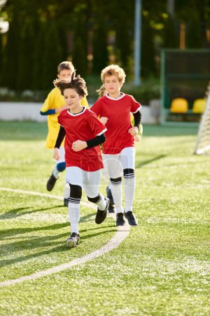 Téléchargez les photos : Un groupe de jeunes enfants, pleins d'énergie et d'excitation, traverse le terrain de soccer au sprint tout en jouant à un jeu amusant ensemble. - en image libre de droit