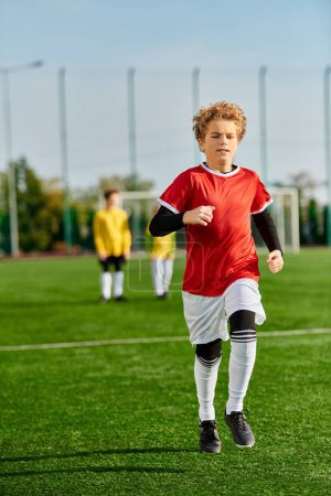 Téléchargez les photos : Un jeune garçon sprinte joyeusement à travers un terrain de soccer vert luxuriant, avec l'accent sur son mouvement agile et l'enthousiasme pour le jeu. - en image libre de droit