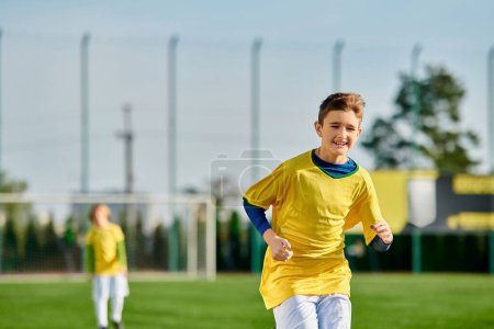 Ein kleiner Junge im leuchtend gelben Hemd spielt begeistert Fußball und kickt den Ball gekonnt auf einem Rasenplatz.