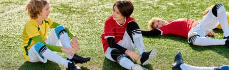 Deux jeunes garçons s'assoient sur l'herbe, les pieds touchant la terre. Ils apparaissent perdus dans la pensée, regardant au loin avec un sentiment d'émerveillement et de curiosité.