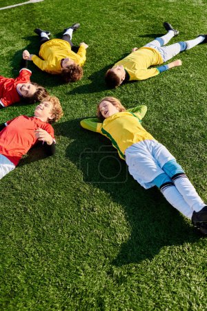 A group of young boys with various expressions are lying down on top of a lush green field, surrounded by natures beauty. They seem relaxed and content, soaking up the sun and enjoying each others company.