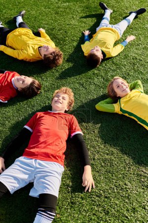 Téléchargez les photos : Groupe de jeunes hommes allongés confortablement sur un champ vert animé, se prélassant dans la chaleur du soleil. - en image libre de droit