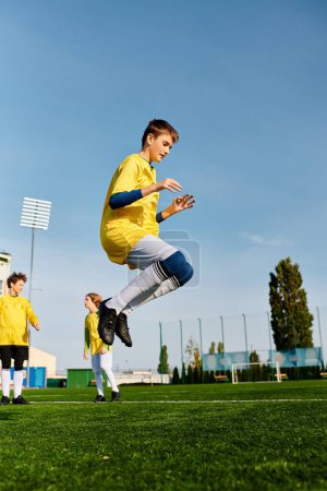 On voit un jeune homme habile frapper un ballon de football sur un vaste terrain. Sa technique précise et son comportement ciblé témoignent du dévouement et de la passion pour le sport..