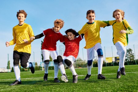 Téléchargez les photos : Un groupe animé de jeunes enfants jouant joyeusement un jeu de football sur un terrain herbeux, courant, donnant des coups de pied au ballon, et s'acclamant mutuellement. - en image libre de droit