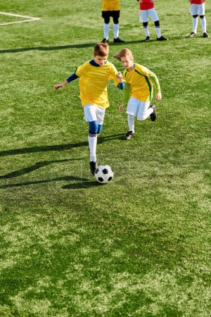 Téléchargez les photos : Une scène vibrante se déroule alors qu'un groupe de jeunes enfants jouent à un jeu enthousiaste de football sur un terrain ensoleillé. Ils courent, donnent des coups de pied et passent le ballon, mettant en valeur le travail d'équipe et la camaraderie. - en image libre de droit