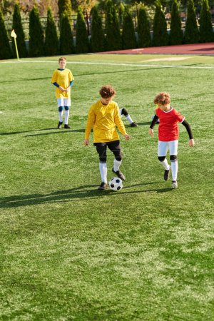 Grupa energicznych małych dzieci zaangażowanych w żywą grę w piłkę nożną, kopiących piłkę w tę i z powrotem na słonecznym polu z radością i entuzjazmem.