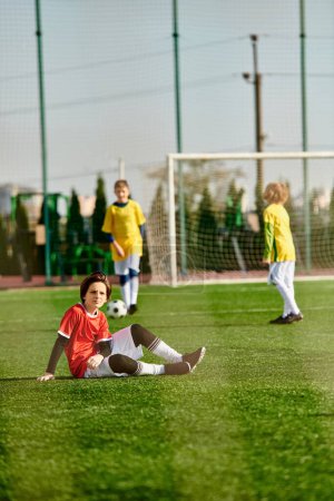 Téléchargez les photos : Un groupe de jeunes enfants enthousiastes jouent à un jeu animé de football. Ils courent, dribblent, passent et donnent des coups de pied au ballon sur un terrain herbeux, faisant preuve de travail d'équipe et d'esprit sportif. - en image libre de droit