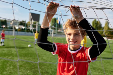 Un jeune garçon se tient en confiance devant un but de football, concentré sur la marque d'un but. Sa posture respire la détermination et la passion pour le jeu, alors qu'il se prépare à prendre un coup de feu.