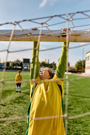 Ein kleiner Junge in einem leuchtend gelben und grünen Outfit greift freudig nach oben, um einen Fußball zu fangen, der voller Vorfreude auf ihn zufliegt..