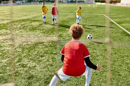 Téléchargez les photos : Un groupe de jeunes enfants jouant énergiquement à un jeu de football, courir, donner des coups de pied et passer le ballon sur un terrain vert. - en image libre de droit