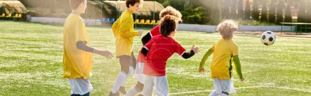 Un groupe de jeunes enfants jouant énergiquement à un jeu de football sur un terrain vert. Ils dribblent, passent et tirent la balle tout en faisant preuve de travail d'équipe et de détermination.