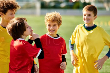 Téléchargez les photos : Un groupe de jeunes garçons énergiques en uniforme de soccer se tiennent ensemble sur le terrain de soccer vert dynamique, prêt pour un match. Leurs visages font preuve de détermination et d'excitation alors qu'ils se préparent à montrer leurs compétences. - en image libre de droit