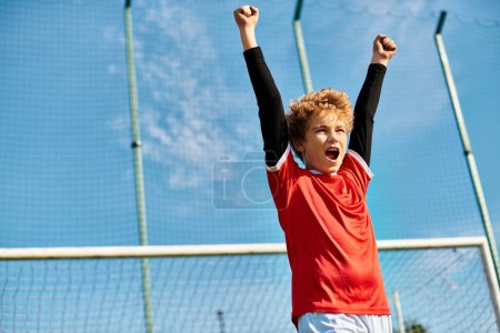 Téléchargez les photos : Un jeune garçon se tient sur le court de tennis, tenant une raquette de tennis à la main. Son regard concentré laisse entrevoir sa détermination et sa passion pour le jeu, alors qu'il se prépare à servir ou à rendre la balle. - en image libre de droit