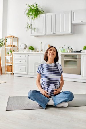 A mature woman practices yoga on a mat in her cozy kitchen.