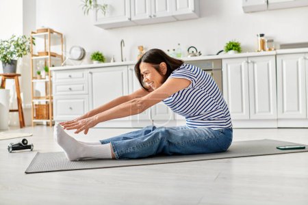 Téléchargez les photos : Femme mûre en vêtements confortables s'étend sur un tapis de yoga à la maison. - en image libre de droit