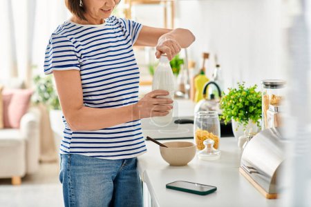 Una mujer en ropa de casa acogedora, de pie en una cocina, preparando comida.