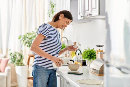 A woman in cozy homewear standing in a kitchen, preparing food.