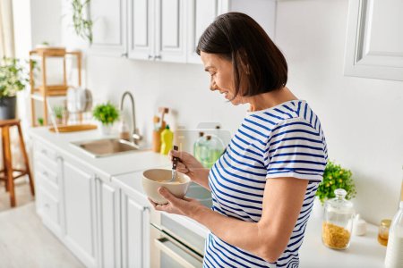 Woman in cozy homewear holding a bowl of food in a kitchen.