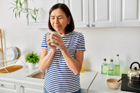 Eine gemütliche Frau genießt eine Tasse etwas in einer ruhigen Küche.