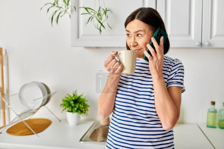 Woman in cozy homewear holding coffee cup, talking on phone.