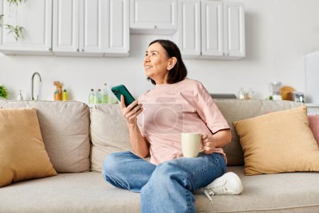 Stylish woman in comfy attire using smartphone on couch.