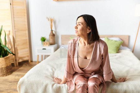 Téléchargez les photos : Une femme mûre en tenue confortable se relaxant sur un lit dans une chambre sereine. - en image libre de droit