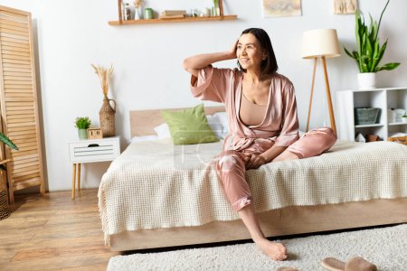 A mature woman in cozy homewear sitting on a bed in a bedroom, looking relaxed and serene.