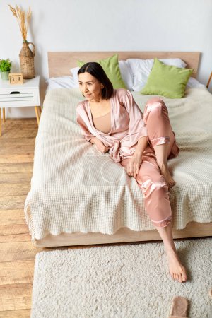 Una mujer en ropa de casa acogedora se sienta en una cama en un dormitorio.
