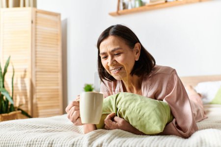 A woman in cozy homewear enjoys a cup of coffee while lounging on a bed.