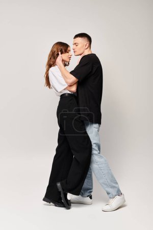 Photo for A young man and woman share an intimate dance in a studio, their bodies moving gracefully in sync to the music. - Royalty Free Image