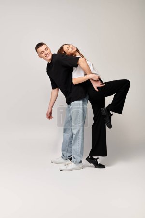 Foto de A man and a woman in a studio setting, posing gracefully together for a photograph against a grey background. - Imagen libre de derechos