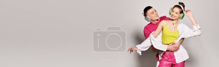 Photo for A stylish young couple in love, posing for a picture in a studio with a grey background. - Royalty Free Image