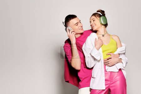 Téléchargez les photos : Un jeune couple élégant amoureux debout ensemble dans un studio, sur un fond gris. - en image libre de droit
