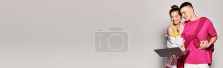 Téléchargez les photos : Un jeune couple de femmes en tenue élégante se tient ensemble sur un fond gris dans un cadre de studio. - en image libre de droit