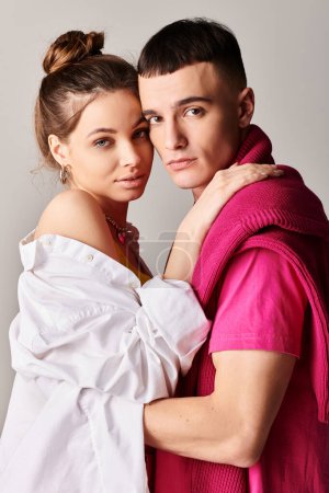 Téléchargez les photos : Un jeune couple élégant se tient ensemble dans un studio, mettant en valeur leur amour avec un fond gris. - en image libre de droit
