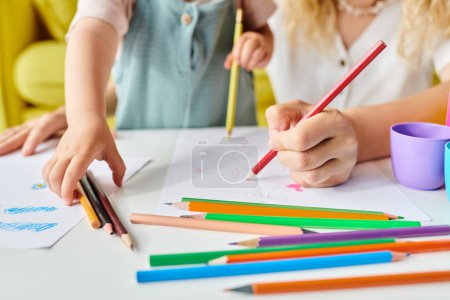 Mutter und Tochter mit Bleistiften, erforschen Kreativität und gemeinsames Lernen an einem Tisch.