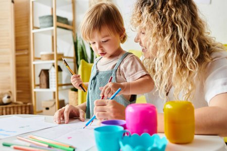 Curly mother and her toddler daughter engage in crafts using Montessori method of education at home.