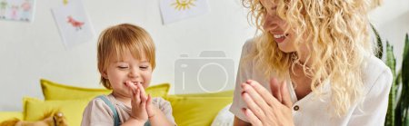 A curly-haired mother and her toddler daughter engage in Montessori activities on a cozy couch at home.
