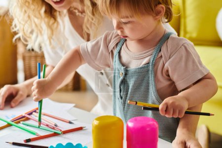 A curly mother and her toddler daughter are immersed in crafting together, using the Montessori method of education at home.