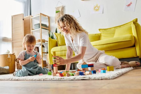 A curly mother engaging her toddler daughter with Montessori activities on the floor.