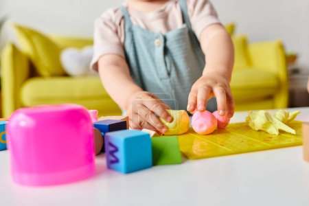 Kleinkind spielt und lernt fröhlich mit Montessori-Spielzeug auf dem heimischen Tisch.