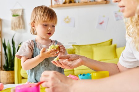 Eine Mutter mit lockigem Haar und ihre kleine Tochter beschäftigen sich zu Hause spielerisch mit Montessori-Spielzeug.