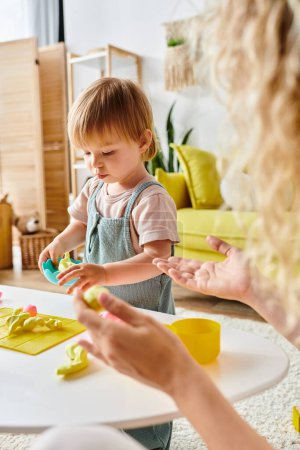 Una madre rizada y su hija pequeña juegan felizmente con juguetes, abrazando el método Montessori de educación en el hogar.