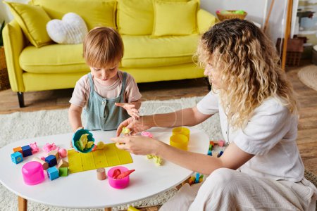 A curly mother engages with her toddler daughter in Montessori play, exploring toys together in a warm home setting.