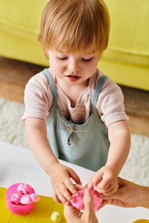 A young child plays happily with a dough, exploring the Montessori method of education at home.