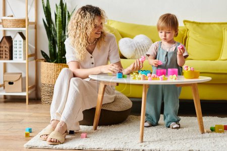 A curly-haired mother and her toddler daughter engage in Montessori activities in a cozy living room setting.