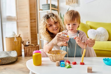 A curly mother and her toddler daughter engage in playful learning with wooden toys at home, enjoying the Montessori method of education.