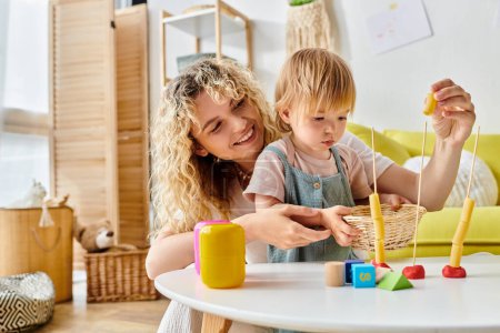 A curly-haired mother and her toddler daughter engage in play as they embrace the Montessori method at home.