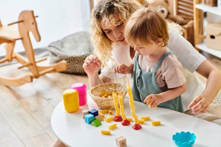 Eine lockige Mutter und ihre kleine Tochter spielen Montessori, erkunden Spielzeug und lernen gemeinsam zu Hause.